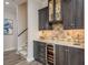 Basement wet bar with a wine refrigerator and custom stone backsplash at 600 Reserve Ln, Dunedin, FL 34698