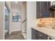 Hallway wet bar with a wine refrigerator and stone tile backsplash at 600 Reserve Ln, Dunedin, FL 34698