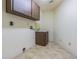 Functional laundry room features tiled floors, wooden cabinets, and utility sink with washer/dryer hookups at 601 Riviera Bay Ne Dr, St Petersburg, FL 33702