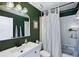 Bathroom featuring a white vanity and commode contrasted by dark green walls and a shower/tub combo at 6262 142Nd N Ave # 1106, Clearwater, FL 33760