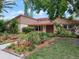 Charming single-story home with lush tropical landscaping and a well-manicured lawn at 65 Harbor Woods Cir, Safety Harbor, FL 34695