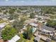 Aerial view of houses in a suburban neighborhood with pools, green trees, and a glimpse of a lake in the background at 9100 2Nd N St, St Petersburg, FL 33702