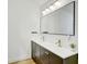 Modern bathroom with a double sink vanity, brass fixtures, and decorative mirror at 9100 2Nd N St, St Petersburg, FL 33702