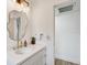 Remodeled bathroom with white vanity, brass fixtures and unique decorative mirror at 9100 2Nd N St, St Petersburg, FL 33702