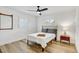 Well-lit bedroom with hardwood floors, a large window, ceiling fan, and a comfortable bed at 9100 2Nd N St, St Petersburg, FL 33702
