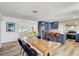 A kitchen area with a long wooden table and seating for six with a view into the living room at 9100 2Nd N St, St Petersburg, FL 33702