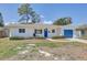 Charming single-story home with a blue front door, attached garage, neat landscaping, and healthy grass in the front yard at 9100 2Nd N St, St Petersburg, FL 33702