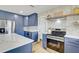 A lovely kitchen with stainless steel appliances, modern blue cabinets and a beautiful backsplash at 9100 2Nd N St, St Petersburg, FL 33702