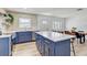 Open-concept kitchen and dining area, complete with stainless steel appliances, blue cabinets and wooden flooring at 9100 2Nd N St, St Petersburg, FL 33702