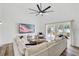 Bright living room features a large sectional sofa, ceiling fan, and sliding glass doors to the backyard at 9100 2Nd N St, St Petersburg, FL 33702