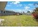 The backyard has a shed, grass, and a blue house at 940 57Th N Ave, St Petersburg, FL 33703