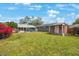 The backyard area features a shed, a blue home, and lush green grass at 940 57Th N Ave, St Petersburg, FL 33703
