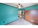 Bedroom features teal walls with black trim, carpet, and a ceiling fan with closet access at 940 57Th N Ave, St Petersburg, FL 33703