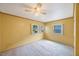 Carpeted bedroom with ceiling fan, yellow walls, and two windows at 940 57Th N Ave, St Petersburg, FL 33703