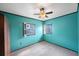 Bedroom features teal walls with black trim, carpet, and two windows for natural light at 940 57Th N Ave, St Petersburg, FL 33703