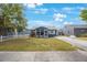 Charming single-story blue home featuring a screened-in porch and a well-maintained front yard at 940 57Th N Ave, St Petersburg, FL 33703