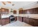 Kitchen showcasing dark wood cabinets, tiled flooring, and a stainless steel oven range at 940 57Th N Ave, St Petersburg, FL 33703