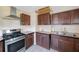 Kitchen featuring dark wood cabinets, tiled flooring, and a stainless steel oven range at 940 57Th N Ave, St Petersburg, FL 33703