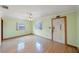 Bright living room with hardwood floors, a ceiling fan, and natural light from two windows at 940 57Th N Ave, St Petersburg, FL 33703