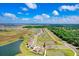 An aerial showcases the community's layout with ponds and a neighborhood of houses against lush greenery on a clear day at 9617 Branching Ship Trce, Wesley Chapel, FL 33545