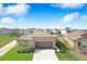 An aerial view shows a well-maintained home with a manicured lawn and a long driveway amid a suburban neighborhood at 9617 Branching Ship Trce, Wesley Chapel, FL 33545