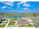 An aerial shot shows the home's backyard near a pond in a community with a lake and green spaces on a clear day at 9617 Branching Ship Trce, Wesley Chapel, FL 33545