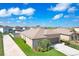 An aerial view showcases a well-kept tan home with manicured lawns in a well-planned community under a beautiful sky at 9617 Branching Ship Trce, Wesley Chapel, FL 33545