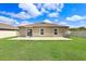 Rear view of home features a patio, sliding glass door and large backyard at 9617 Branching Ship Trce, Wesley Chapel, FL 33545