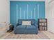 Comfortable bedroom featuring a cozy loveseat and stylish blue accent wall at 9617 Branching Ship Trce, Wesley Chapel, FL 33545