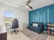 Well-lit bedroom with ceiling fan, blue accent wall, and desk area at 9617 Branching Ship Trce, Wesley Chapel, FL 33545