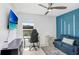 Versatile bedroom setup showcasing a gaming setup and a relaxing blue couch at 9617 Branching Ship Trce, Wesley Chapel, FL 33545