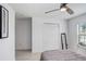 Bright bedroom featuring a ceiling fan, closet, neutral walls, and a mirror near the window at 9617 Branching Ship Trce, Wesley Chapel, FL 33545