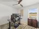 Home office with a dual monitor setup, dark colored desk, wooden filing cabinet, and a ceiling fan at 9617 Branching Ship Trce, Wesley Chapel, FL 33545