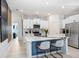 Bright kitchen features a center island with white cabinetry, stainless steel appliances, and modern countertops at 9617 Branching Ship Trce, Wesley Chapel, FL 33545