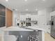 Modern kitchen featuring a large island with bar seating and stylish decorative wall panels at 9617 Branching Ship Trce, Wesley Chapel, FL 33545