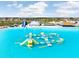 Expansive resort lagoon featuring a water slide, inflatable obstacle course and a tiki bar at 9617 Branching Ship Trce, Wesley Chapel, FL 33545
