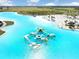 Aerial of the lagoon featuring a water obstacle course with blue water and a white sand beach at 9617 Branching Ship Trce, Wesley Chapel, FL 33545