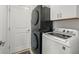 Efficient laundry room featuring a stacked washer and dryer with ample storage space at 9617 Branching Ship Trce, Wesley Chapel, FL 33545