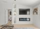 Bright living room featuring built-in shelves, a modern fireplace, and large flat screen television at 9617 Branching Ship Trce, Wesley Chapel, FL 33545