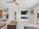Bright living room featuring a fireplace, TV, view into the kitchen, and sliding glass doors at 9617 Branching Ship Trce, Wesley Chapel, FL 33545