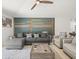 Comfortable living room with modern decor, gray sectional sofa, accent wall, and a ceiling fan at 9617 Branching Ship Trce, Wesley Chapel, FL 33545