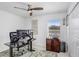 Home office includes a sleek black desk, dual monitors, and a ceiling fan at 9617 Branching Ship Trce, Wesley Chapel, FL 33545