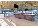 Thatched outdoor bar featuring dark wood accents, concrete floors, two flatscreen televisions, and plenty of seating at 9617 Branching Ship Trce, Wesley Chapel, FL 33545