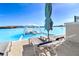 Relaxing poolside view featuring lounge chairs, shade umbrella and floating cabana on aquamarine water at 9617 Branching Ship Trce, Wesley Chapel, FL 33545