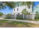 A well-maintained townhome with a gray fence, lush landscaping, and a concrete walkway at 98 29Th S St, St Petersburg, FL 33712