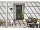 Inviting front entryway with a gray door, decorative wreath, potted plant, and comfortable outdoor chair at 98 29Th S St, St Petersburg, FL 33712