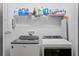 Laundry room with white washer and dryer and overhead shelving at 98 29Th S St, St Petersburg, FL 33712