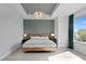 Elegant main bedroom featuring a wooden bed frame, stylish chandelier, and bright natural light at 98 29Th S St, St Petersburg, FL 33712
