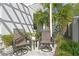 Outdoor patio featuring two swivel chairs, a side table, and beautiful landscaping for relaxing outdoors at 98 29Th S St, St Petersburg, FL 33712