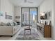 Living room features neutral tones, outdoor balcony, and contemporary furnishings at 100 1St N Ave # 1005, St Petersburg, FL 33701